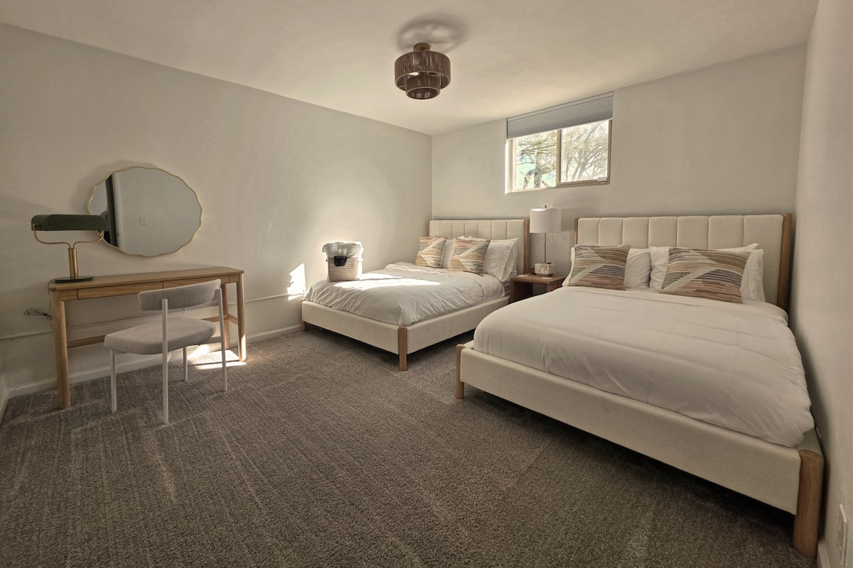 Spavaća soba u prizemlju s dva bračna kreveta i radnim stolom.