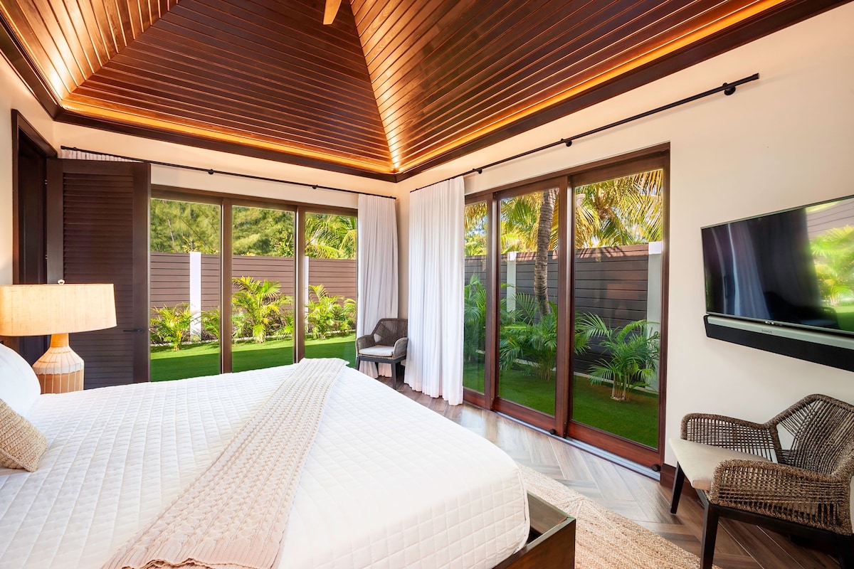 El dormitorio 5 está en el bungalow separado y viene amueblado con una cama tamaño king, TV HD con barra de sonido y acceso a un jardín privado. 