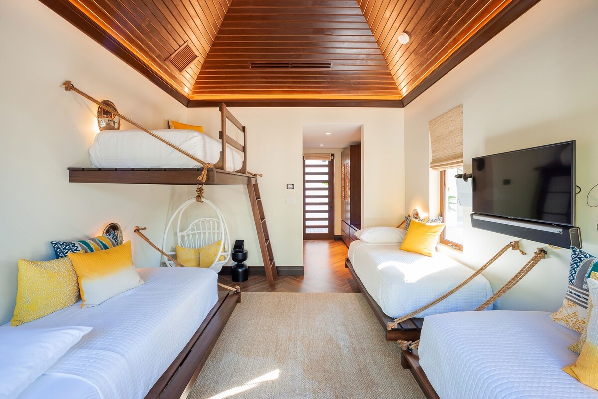 El dormitorio 6 también está en el bungalow separado y está amueblado con 4 camas individuales, un televisor inteligente con barra de sonido y una consola de videojuegos. 