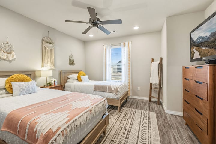 חדר שינה שלישי - שתי מיטות יחיד, מתלה בגדים וטלוויזיה חכמה.