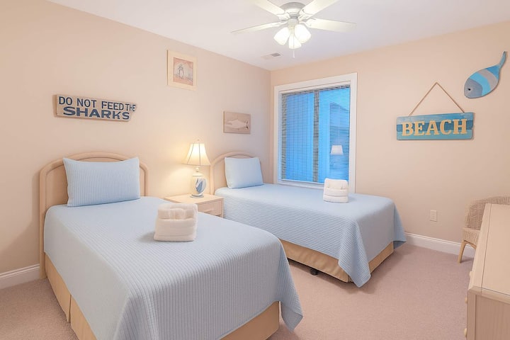 Una acogedora habitación con dos acogedoras camas individuales, que ofrece un espacio flexible para dormir para tu grupo.