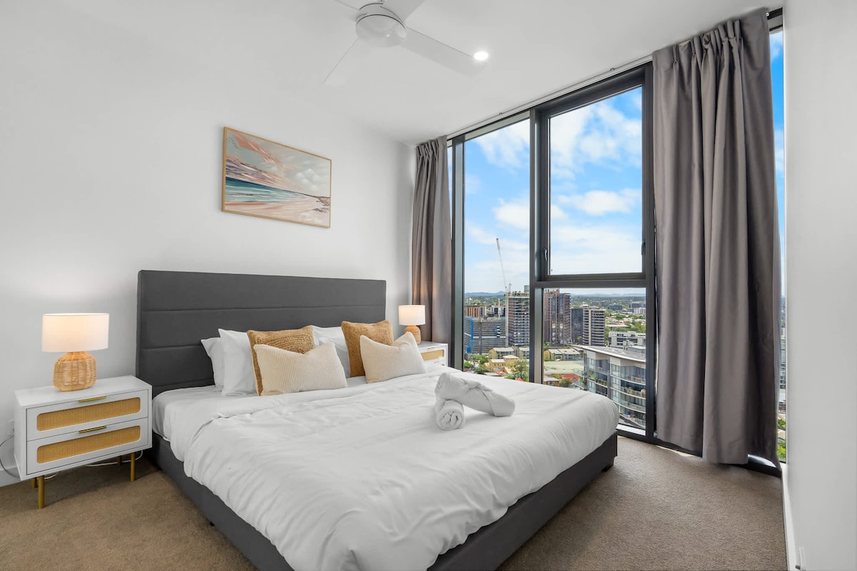 Chambre principale lumineuse avec un très grand lit, un matelas en mousse et de grandes fenêtres donnant sur West End et la rivière.