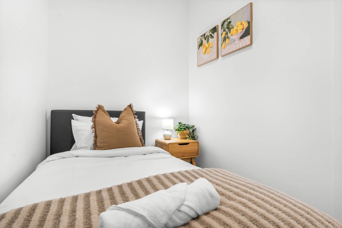 Chambre simple confortable avec table de chevet et lampe de lecture, entièrement climatisée.