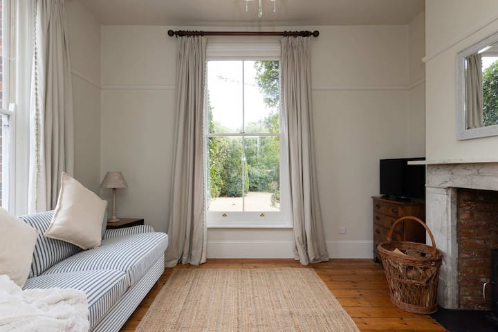 Ljust vardagsrum med utsikt över trädgården och mjuka neutrala toner