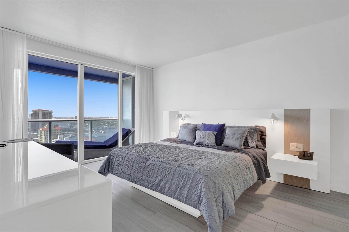 Dormitorio principal con cama King, acceso al balcón y vistas panorámicas al mar y a la ciudad.