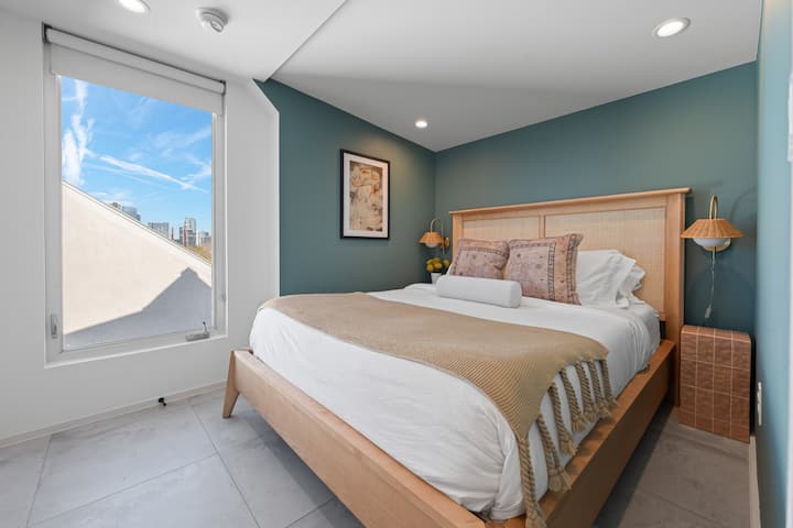 Chumba cha kulala cha msingi kina kitanda cha kifalme na bafu linalofuata.