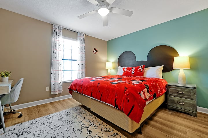 Une chambre Queen amusante et lumineuse avec un décor Disney subtil pour de doux rêves de vacances.