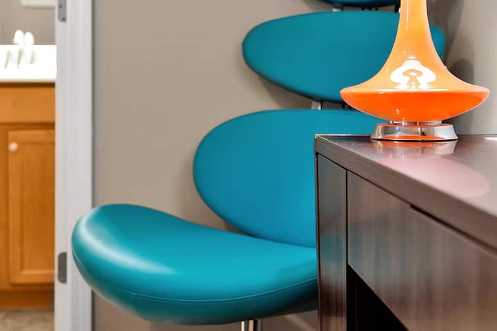 Des chaises turquoise funky et une lampe de style milieu du siècle ajoutent une touche unique et joyeuse au décor de la pièce.