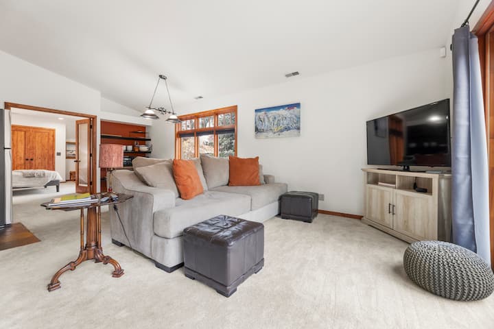 Slnečný salónik s mäkkou sedačkou, televízorom a otvoreným prechodom do spálne