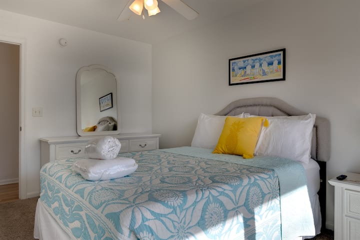 חדר שינה שלישי מואר ומזמין עם מיטת קווין סייז נוחה ועיצוב חוף עליז