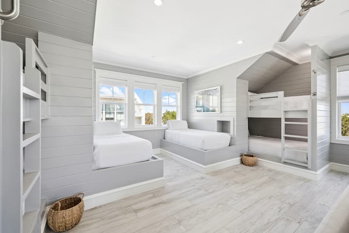 Relájese en su tranquila habitación costera con literas, que cuenta con camas hechas a medida, sábanas suaves y luz natural que entra por las ventanas.