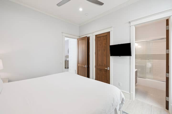 Relájese en su sereno dormitorio blanco, con la comodidad de un ventilador de techo y un baño privado a solo unos pasos.