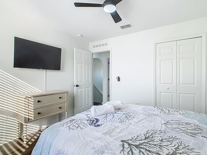 غرفة نوم مع تلفزيون ومدخل خاص يؤدي إلى القاعة الرئيسية.