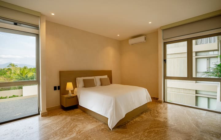 Dormitorio con cama tamaño queen y baño privado.