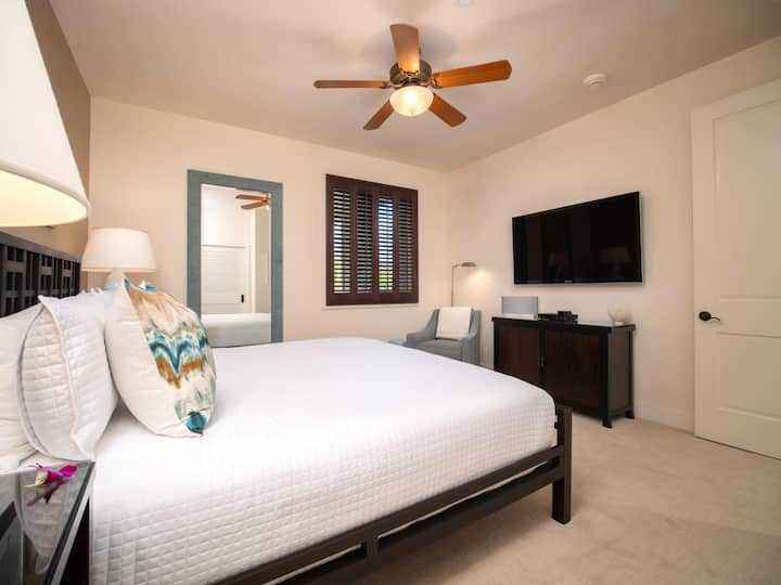 Las persianas de plantación y la iluminación suave hacen que esta habitación King sea acogedora pero espaciosa.