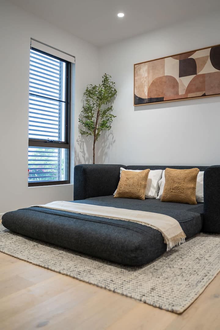 Bäddsoffa i queensize-storlek i vardagsrummet på övervåningen, utformad för avkoppling eller extra sovplats.