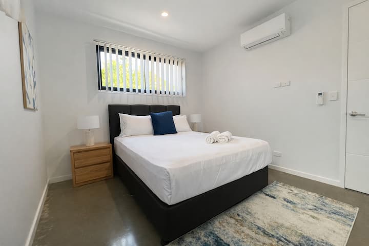 ห้องนอนที่ทันสมัยพร้อมเครื่องปรับอากาศ เตียงขนาดควีนไซส์ ผ้าปูที่นอนใหม่ และแสงธรรมชาติ