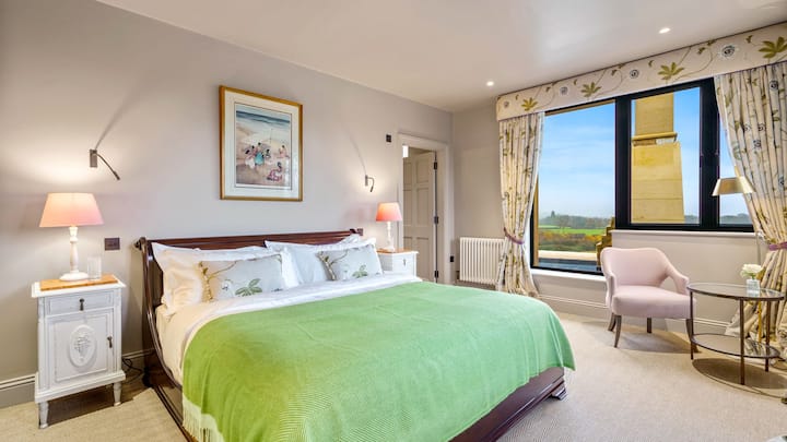 Nježne ružičaste, zelene i pasiflorine tkanine daju ženstveniji izgled drugoj glavnoj spavaćoj sobi. 