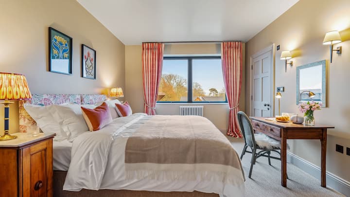 Ova soba je opremljena noćnim ormarićima te toaletnim stolićem i stolicom s mnogo ugrađenog prostora za odlaganje stvari.