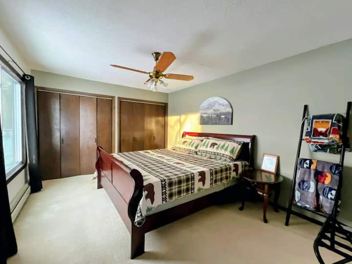 Chumba cha kulala cha ghorofa kuu chenye kitanda cha mfalme na makabati makubwa