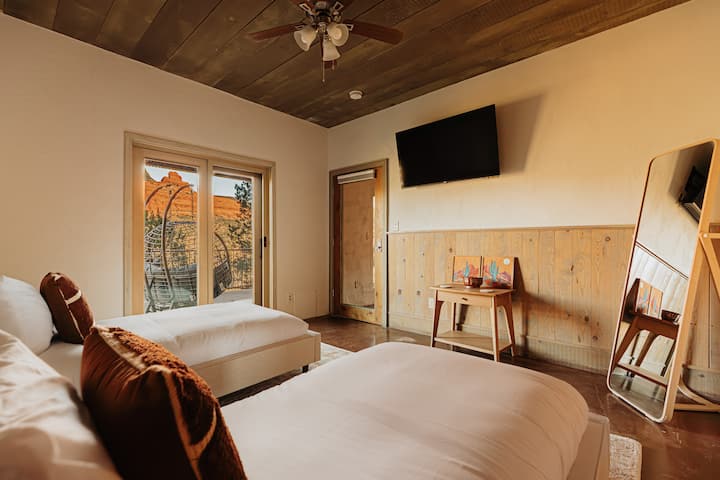 Rest easy in your cozy twin bedroom with stunning red rock views and rustic wooden ceiling charm.