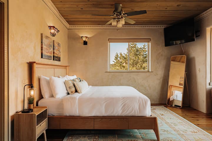 Sink into crisp linens and warm wood tones while your ceiling fan creates the perfect breeze for restful nights.