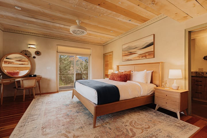 Sink into crisp linens under stunning wood beam ceilings in your serene bedroom retreat with desert views.