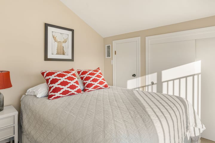 Кревет за гости со перници со живописни црвени шарки.