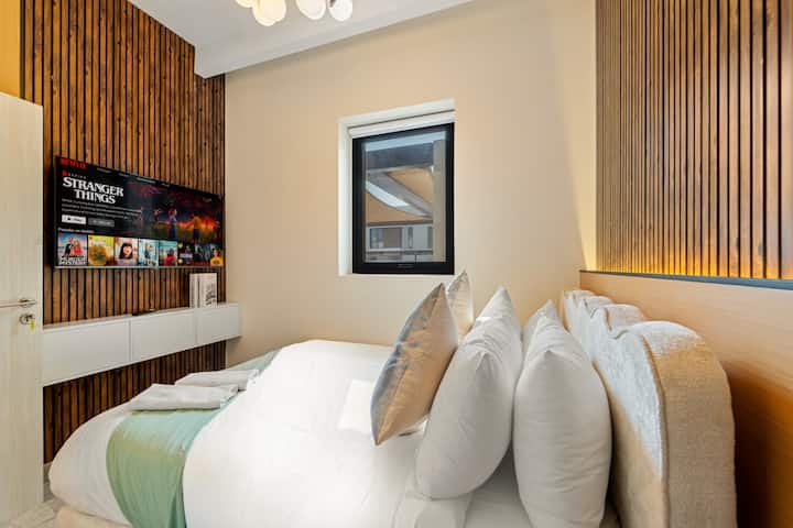 Dormitorio con una cama cómoda, televisor inteligente con Netflix y sábanas, ropa de cama y almohadas completas.