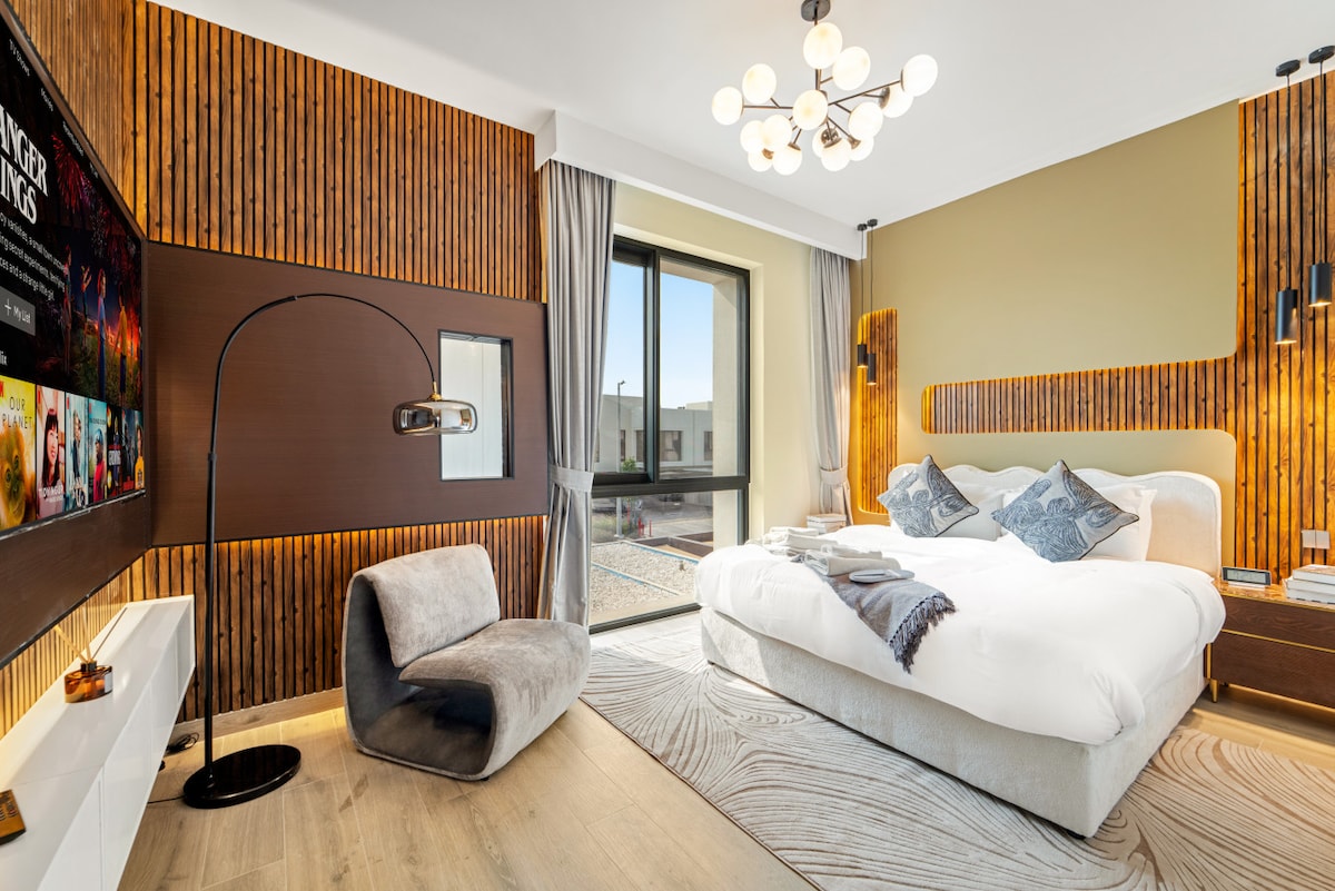 Udobna spavaća soba s udobnim krevetom, svježom posteljinom, jastucima te opuštajućom stolicom i podnom svjetiljkom sa strane ️