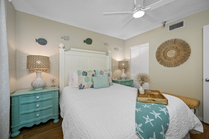 تتميز غرفة نوم الضيوف بسرير كوين وتلفزيون ذكي ومروحة وديكور ساحلي جميل