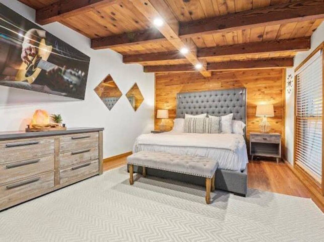 Просторен брачен кревет во Калифорнија под прекрасен дрвен таван, а белиот ѕид ја подобрува природната топлина на дрвото. Големиот телевизор и топлото светло покрај креветот ја прават оваа соба совршено засолниште за релаксација.