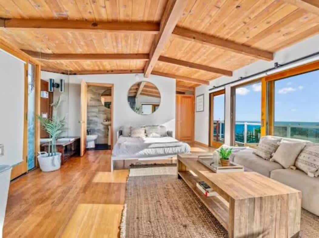 Мирно место за одмор каде што дрвените подови и таваните се среќаваат со бели ѕидови за да создадат мирна, стилска атмосфера. Со удобен кревет и места за седење, како и врати од подот до таванот кои ја пропуштаат сончевата светлина, оваа соба изгледа како светло, проветрено засолниште.