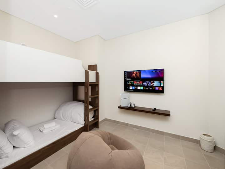 Acomódate en el dormitorio con una litera y televisión lista para streaming durante tu estancia en Dubái. El área de piso abierto y el diseño simple apoyan el tiempo de inactividad relajado, ya sea viendo un programa o relajándose para descansar.
