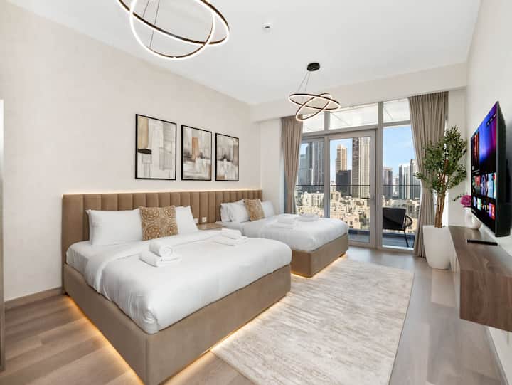 Acomódate en el dormitorio con dos camas espaciosas, iluminación junto a la cama y amplias puertas corredizas que dan la bienvenida a la luz del día durante tu estancia en Dubái. El diseño abierto y las vistas de la ciudad respaldan la comodidad compartida y las noches relajadas en el interior.