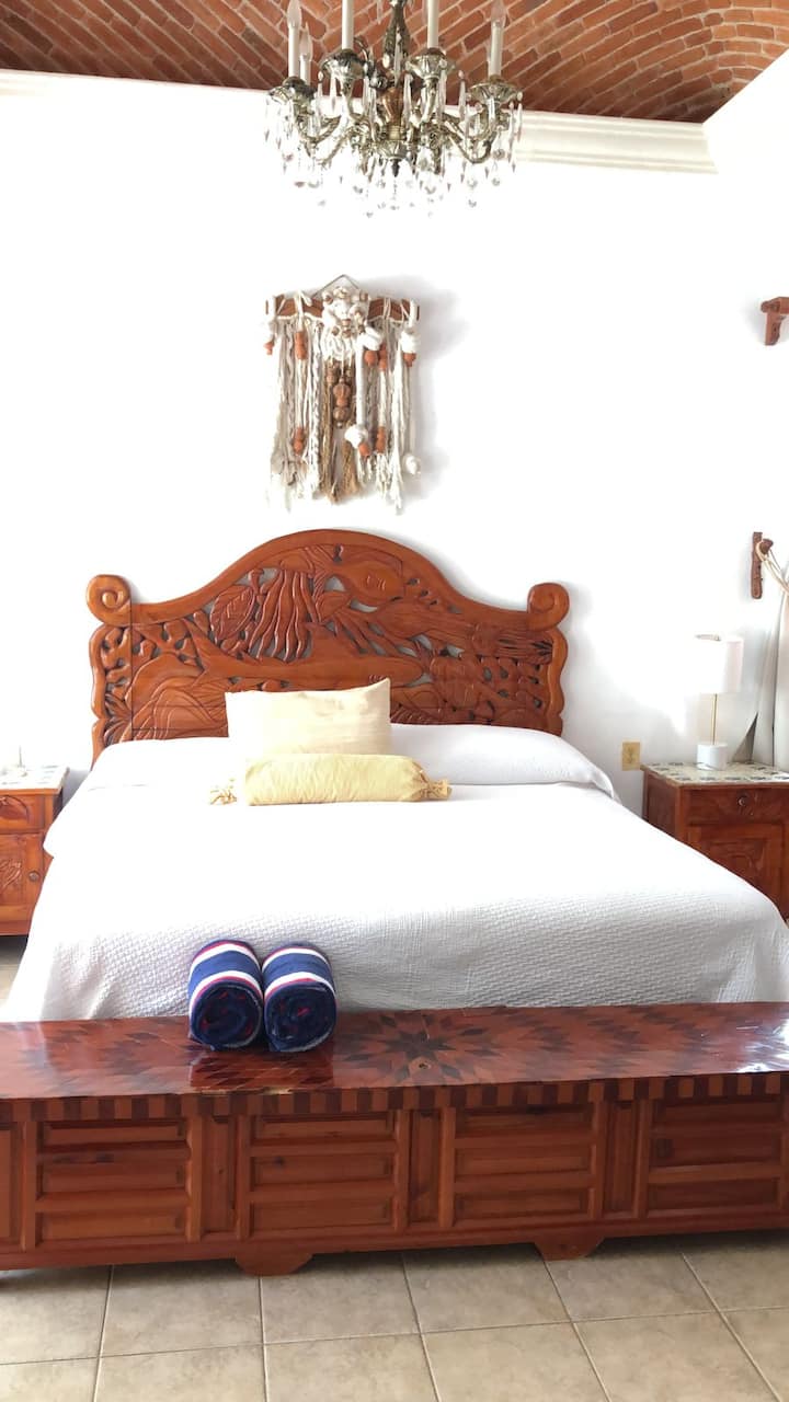 La chambre principale avec son lit King Size et son armoire d'inspiration maya sculptée à la main