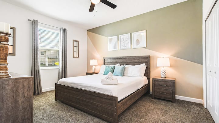 ห้องนอนทันสมัยพร้อมเตียงคิงไซส์ ผนังที่มีเอกลักษณ์ บรรยากาศอบอุ่น และแสงธรรมชาติสว่างมาก
