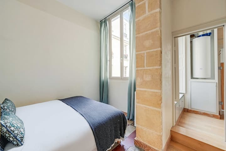 Um quarto com cama queen size e armazenamento embutido.