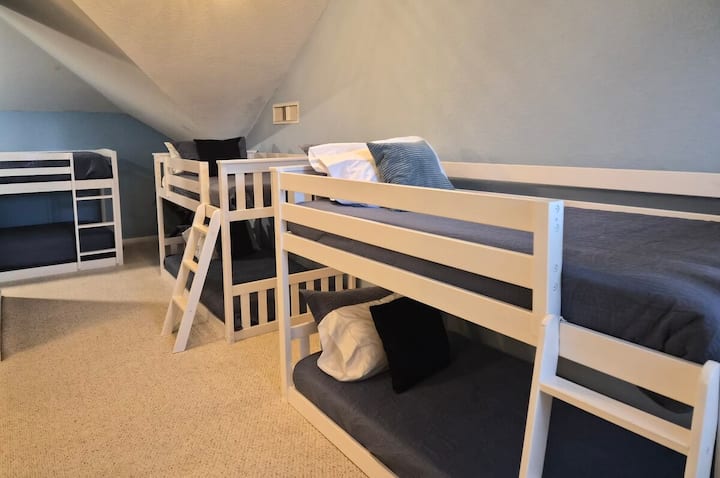 Acogedora habitación tipo loft con literas en el piso de arriba de la casa principal, con tres literas de dos plazas