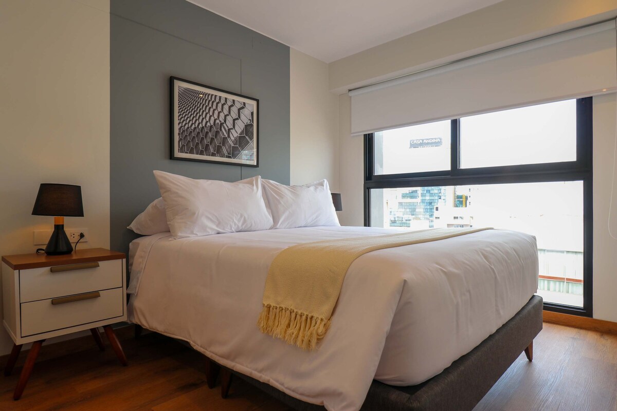 Spavaća soba s udobnim posteljinom i prirodnim svjetlom.