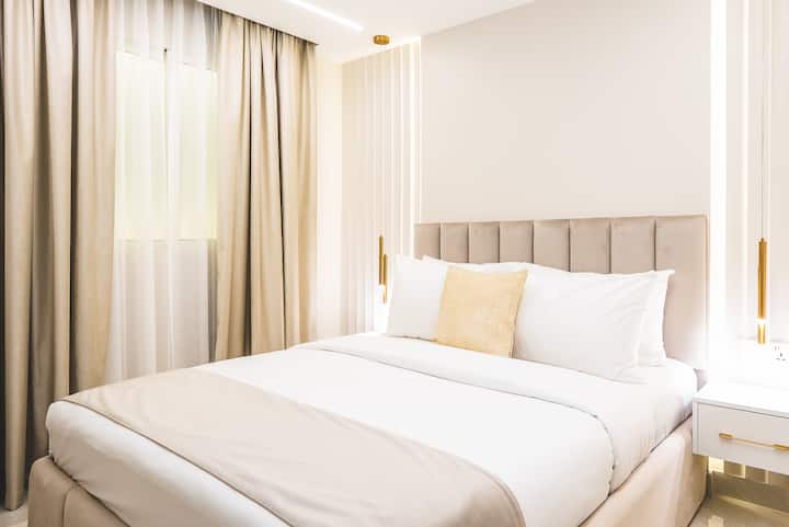 Un dormitorio interior elegante, cuidadosamente diseñado sin luz natural, con un armario empotrado y un tocador que ofrecen un refugio sereno y cómodo.