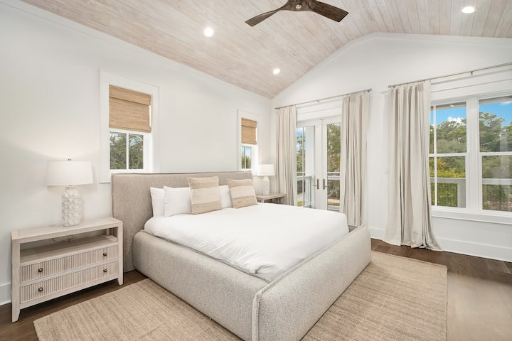 프렌치 도어를 통해 고급스러운 침구와 고요한 자연 풍경을 감상하며 밝고 쾌적한 침실에서 평화롭게 휴식을 취하세요.