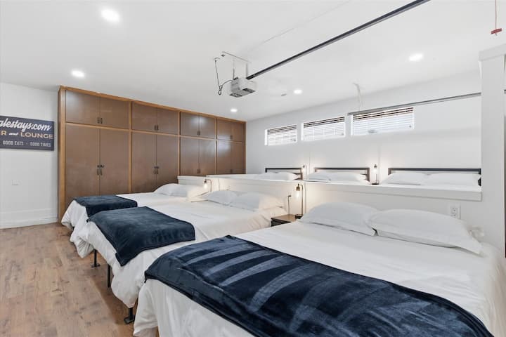 第10间卧室是一间由车库改造的卧室，配备6张全尺寸床、智能电视和衣柜空间。