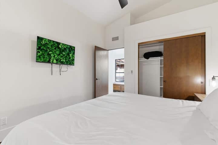 第三间卧室配备一张加大双人床、智能电视和衣柜。