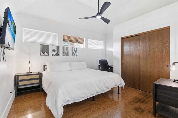 第4间卧室配备一张加大双人床、智能电视、工作空间和衣柜。