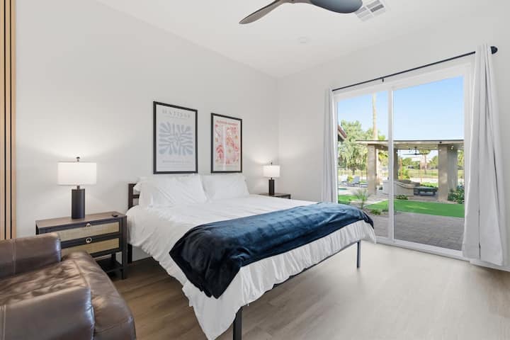 第6间卧室配有2米宽双人床、智能电视、舒适的家具、套间浴室和后院通道。