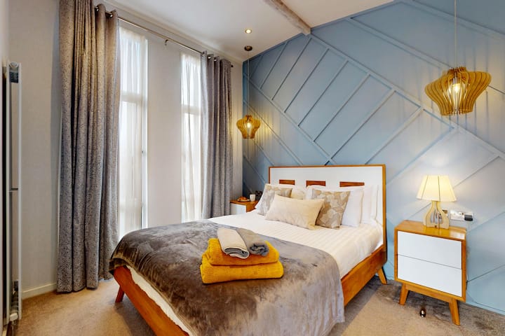 Een heerlijk tweepersoonsbed met nachtkastjes en een eigen badkamer plus een inloopkast.