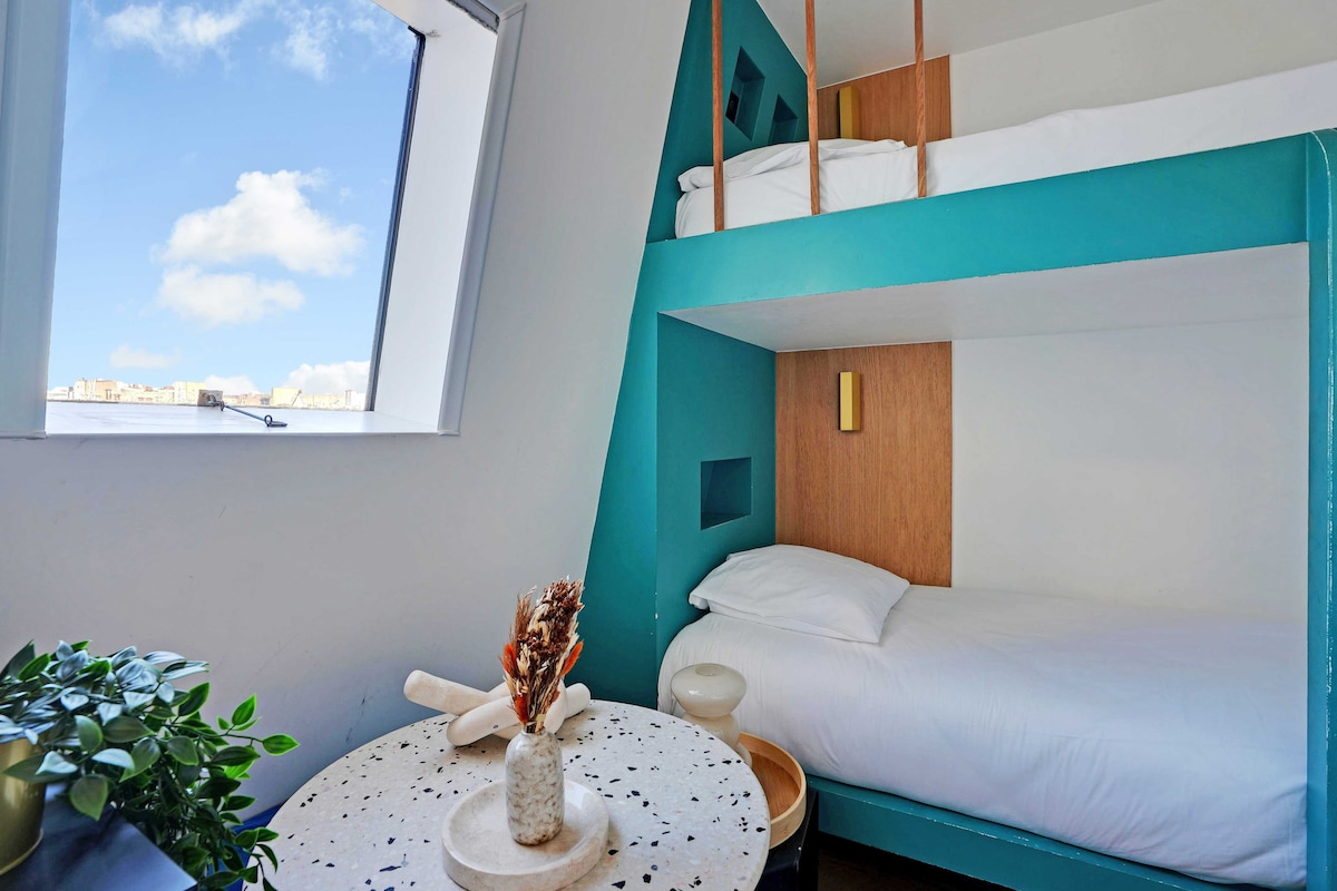 საცხოვრებელი სივრცე ორსართულიანი საწოლებით (ორი ერთადგილიანი საწოლი), ტელევიზორითა და სადილობის ზონით, რომელშიც არის მაგიდა