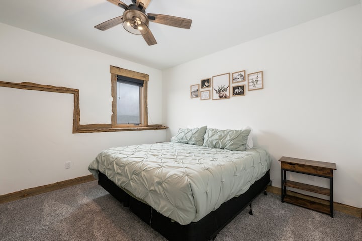 这间舒适的卧室配有柔软的鼠尾草床上用品和质朴的木质装饰，让您尽情享受宁静的睡眠。