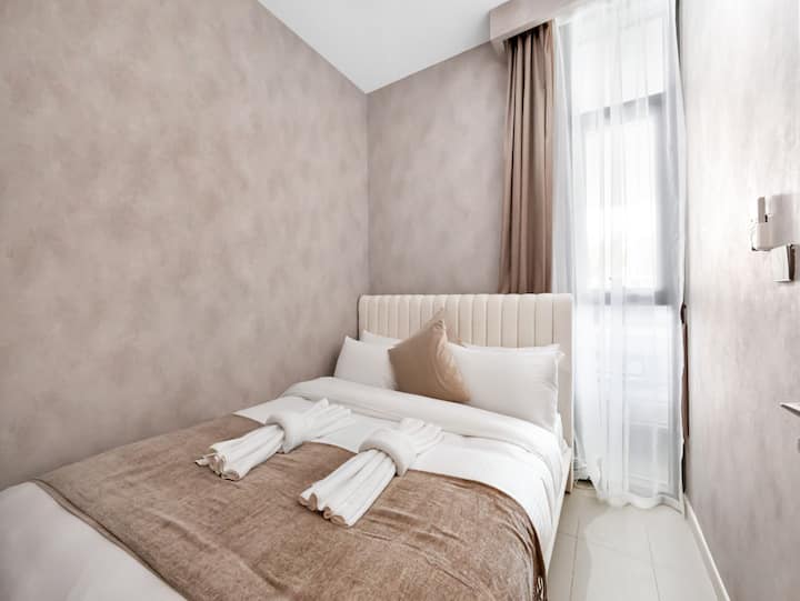 Dormitorio de estilo impecable con texturas suaves y tonos cálidos.